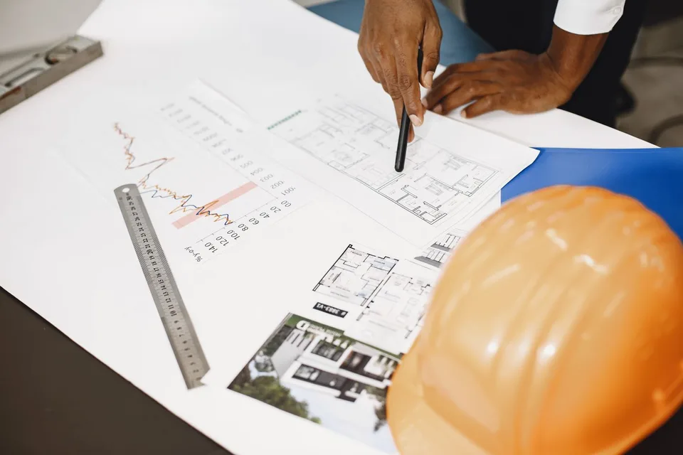 Een professional bestudeert bouwtekeningen van een woning